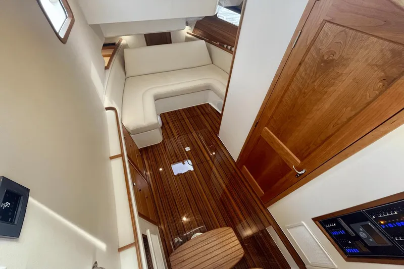  Yacht Photos Pics 2024 MJM 4 yacht interior with wooden flooring and white seating area.