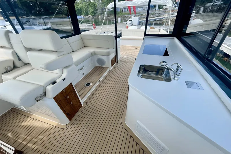  Yacht Photos Pics Luxurious interior of 2024 MJM 4 yacht with white seating and kitchenette.