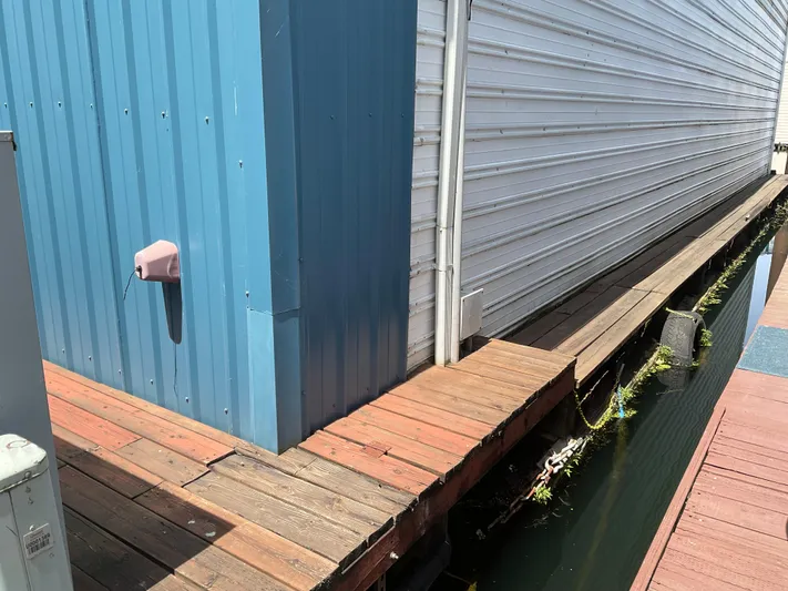  Yacht Photos Pics Wooden walkway beside a custom 1980 boathouse with blue and white siding.