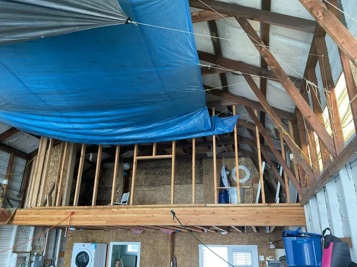  Yacht Photos Pics Interior of a 1980 custom boathouse with exposed beams and blue tarp ceiling.