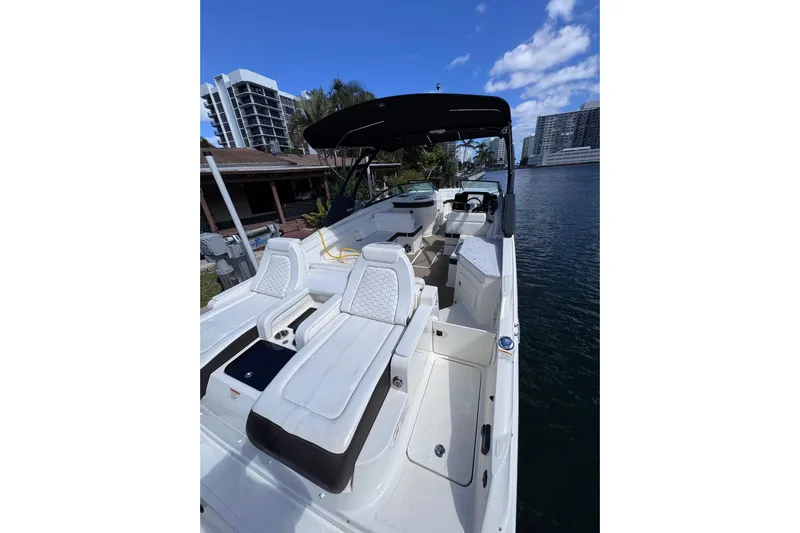  Yacht Photos Pics 2024 Sea Ray SDX 290 Outboard boat with luxurious seating, docked by waterfront buildings.