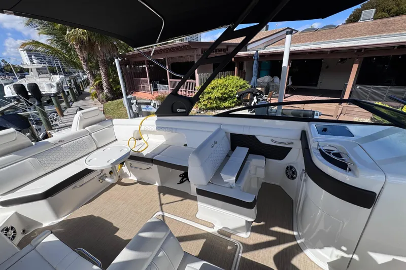  Yacht Photos Pics 2024 Sea Ray SDX 290 Outboard boat interior with seating and table, docked near palm trees.