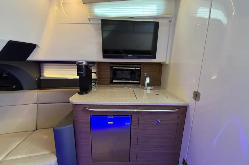  Yacht Photos Pics Interior of 2020 Boston Whaler 420 Outrage with kitchenette, TV, and seating area.