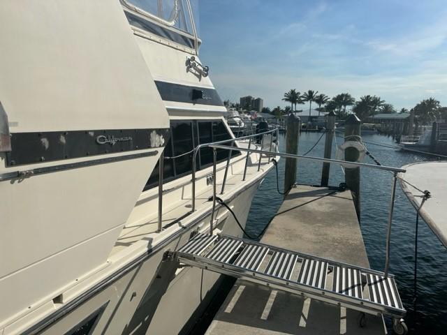 1989 Californian 48 Motor Yacht docked at marina with palm trees in background.