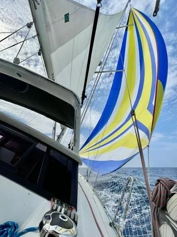  Yacht Photos Pics Sailing on a 2011 Beneteau Sense 50 with vibrant spinnaker against blue sky.