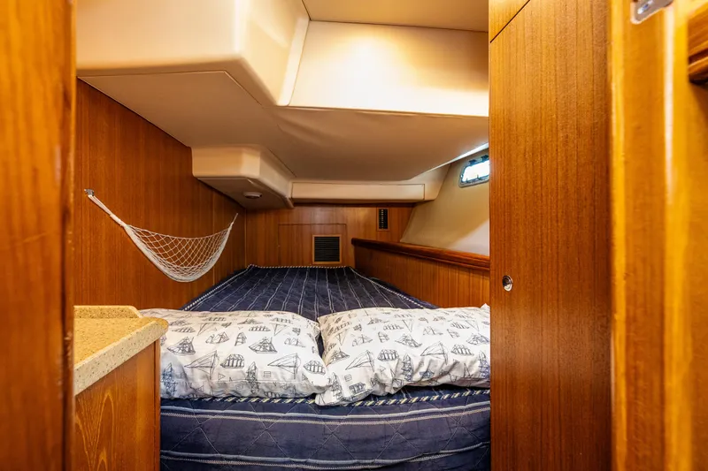 Selkie Yacht Photos Pics 2007 Hunter 41 Deck Salon cabin with cozy bedding and wooden interior.