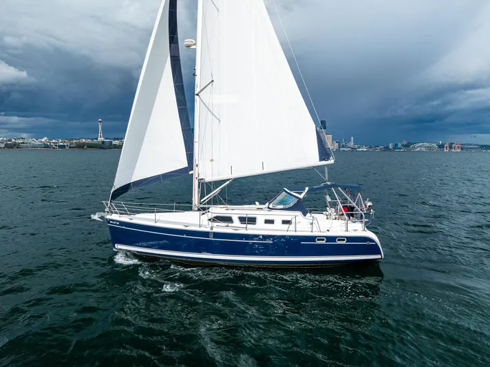 Selkie Yacht Photos Pics Sailing yacht Hunter 41 Deck Salon 2007 on open water with city skyline backdrop.