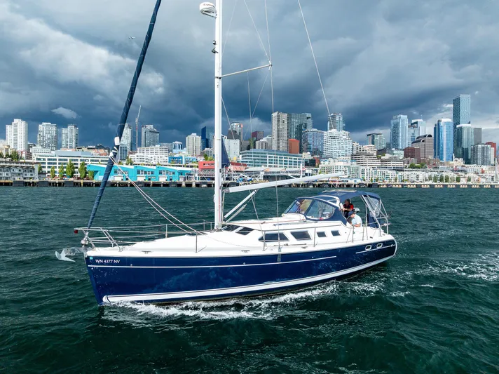 Selkie Yacht Photos Pics Sailboat Hunter 41 Deck Salon 2007 cruising near city skyline under cloudy skies.