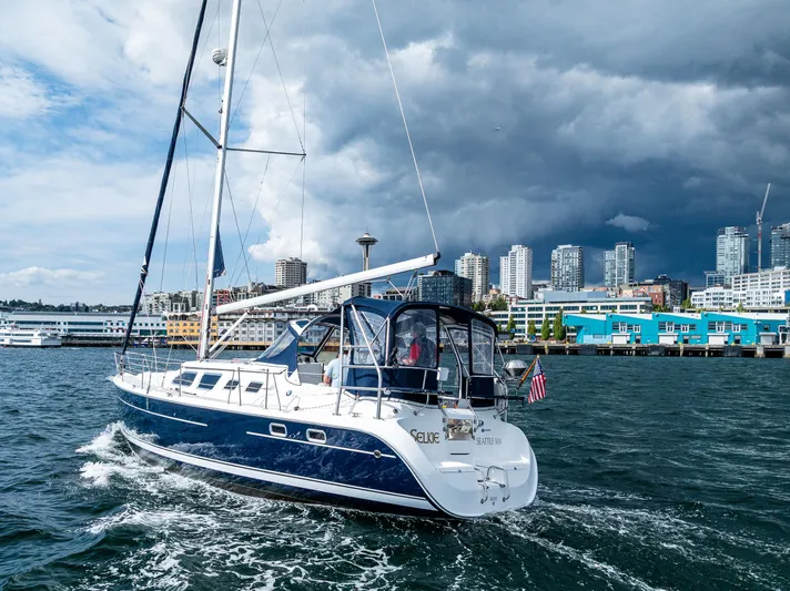 Selkie Yacht Photos Pics 2007 Hunter 41 Deck Salon sailing near urban skyline under dramatic clouds.