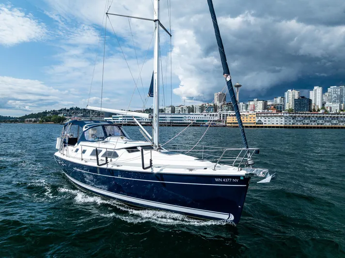 Selkie Yacht Photos Pics 2007 Hunter 41 Deck Salon sailing near urban skyline under dramatic sky.