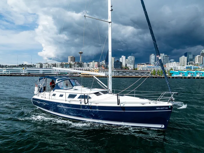 Selkie Yacht Photos Pics 2007 Hunter 41 Deck Salon sailboat cruising near city skyline under dramatic sky.