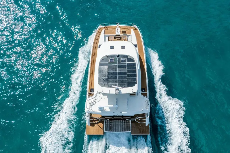 Bikini Bottom Yacht Photos Pics Aerial view of 2023 Granocean 57 yacht cruising in clear blue waters.