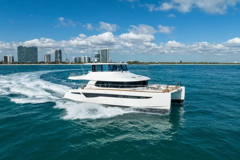 Bikini Bottom Yacht Photos Pics 2023 Granocean 57 yacht cruising near city skyline on a sunny day.