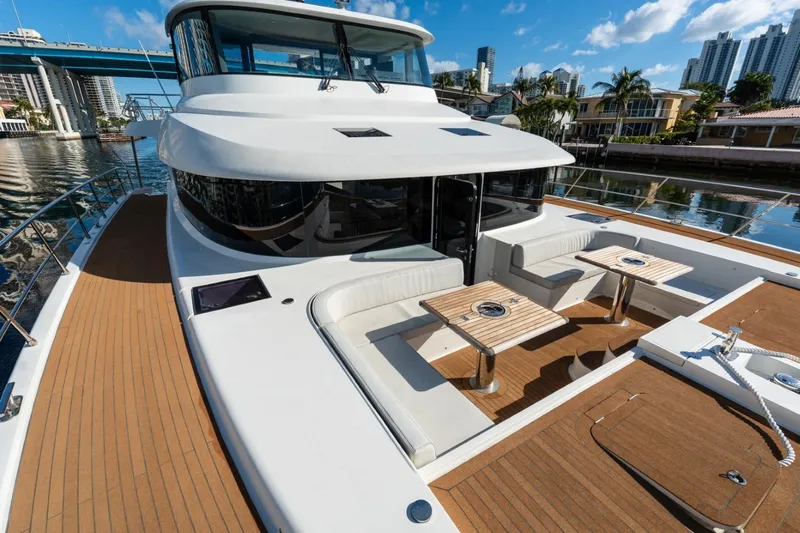 Bikini Bottom Yacht Photos Pics Luxurious 2023 Granocean 57 yacht with spacious deck and seating area, docked in a scenic marina.