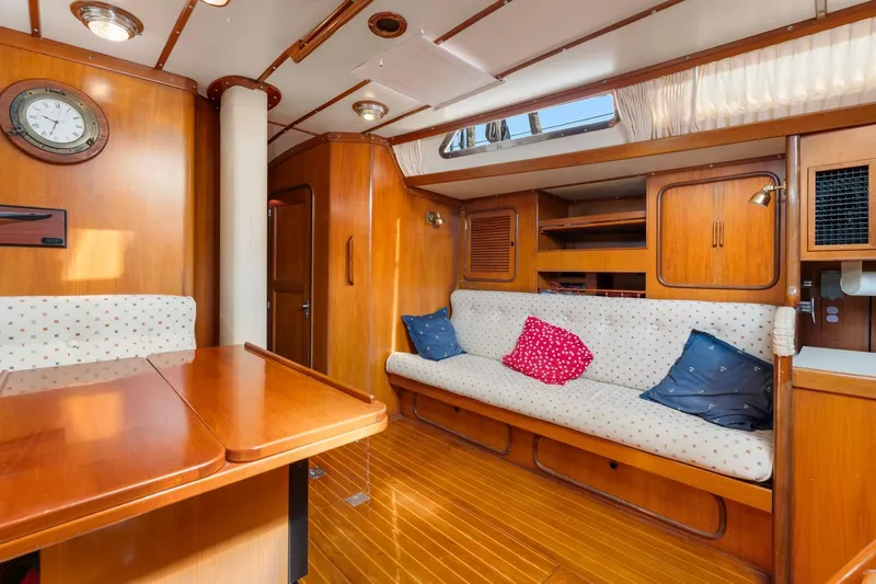 Mandate Yacht Photos Pics Luxurious 1996 Tayana 58 yacht interior with wooden finish and cozy seating area.