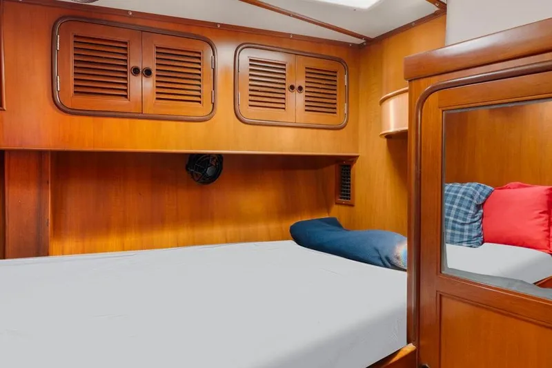 Mandate Yacht Photos Pics Cozy cabin interior of 1996 Tayana 58 yacht with wooden finish and comfortable bedding.