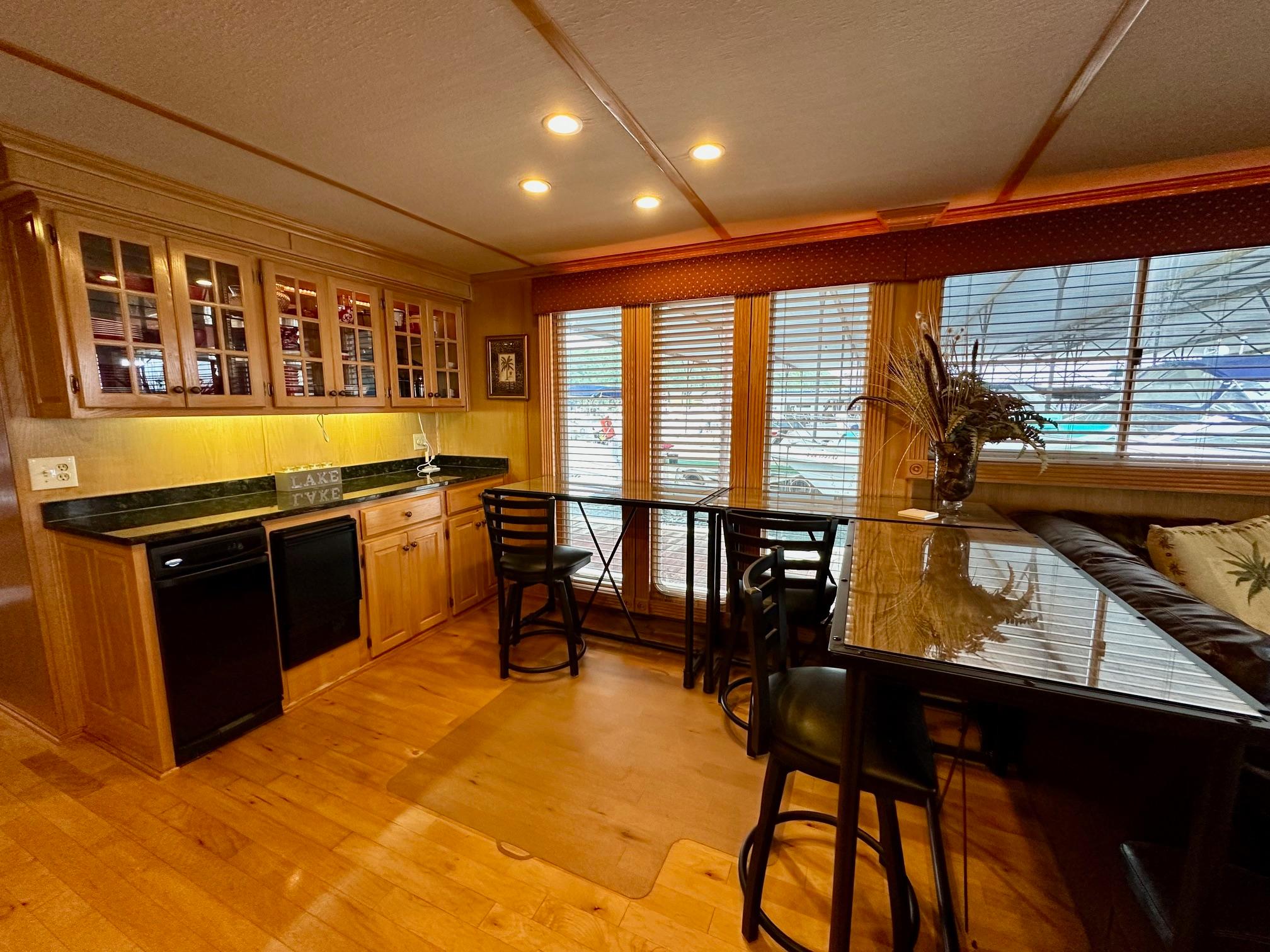 Spacious kitchen area in 2004 Lakeview 16x68 houseboat with wooden cabinets and large windows.