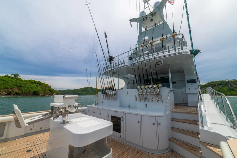 Prime Time Yacht Photos Pics Luxurious 2002 Queenship 98 Yachtfish with fishing rods, docked in scenic waters.