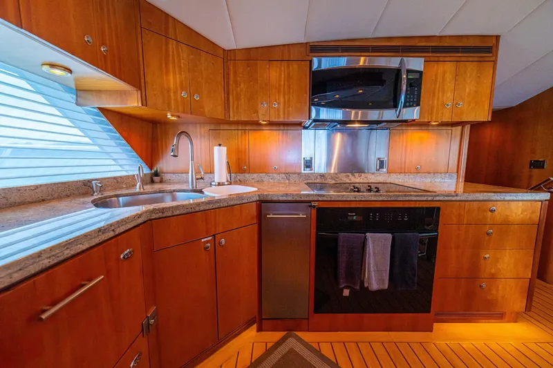 Prime Time Yacht Photos Pics Luxurious kitchen interior of 2002 Queenship 98 Yachtfish with wood cabinetry and modern appliances.