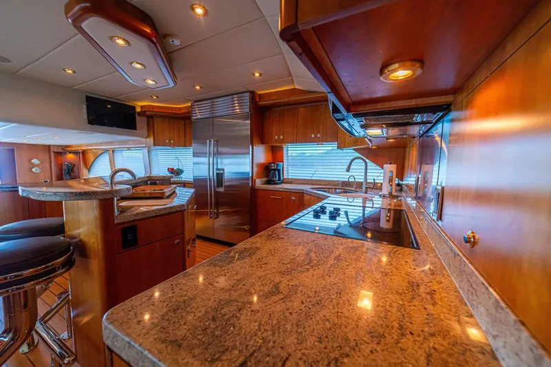 Prime Time Yacht Photos Pics Luxurious kitchen interior of 2002 Queenship 98 Yachtfish with modern appliances and elegant wood finish.