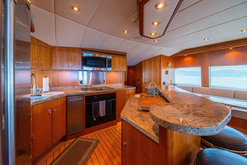 Prime Time Yacht Photos Pics Luxurious kitchen interior of 2002 Queenship 98 Yachtfish with modern amenities and wood finishes.