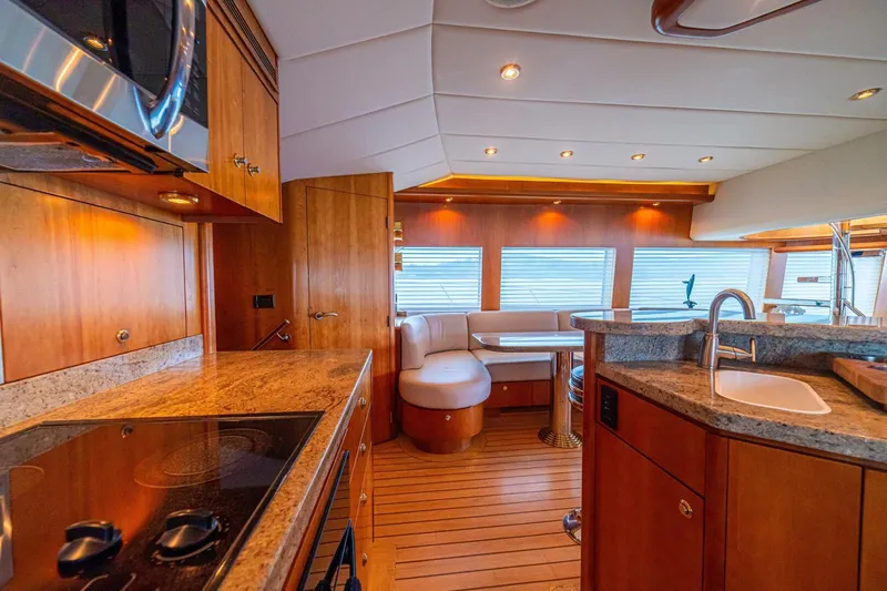 Prime Time Yacht Photos Pics Luxurious 2002 Queenship 98 Yachtfish interior with modern kitchen and elegant seating area.