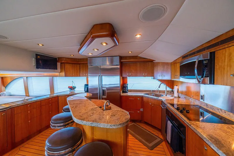 Prime Time Yacht Photos Pics Luxurious kitchen interior of 2002 Queenship 98 Yachtfish with modern appliances and wood cabinetry.