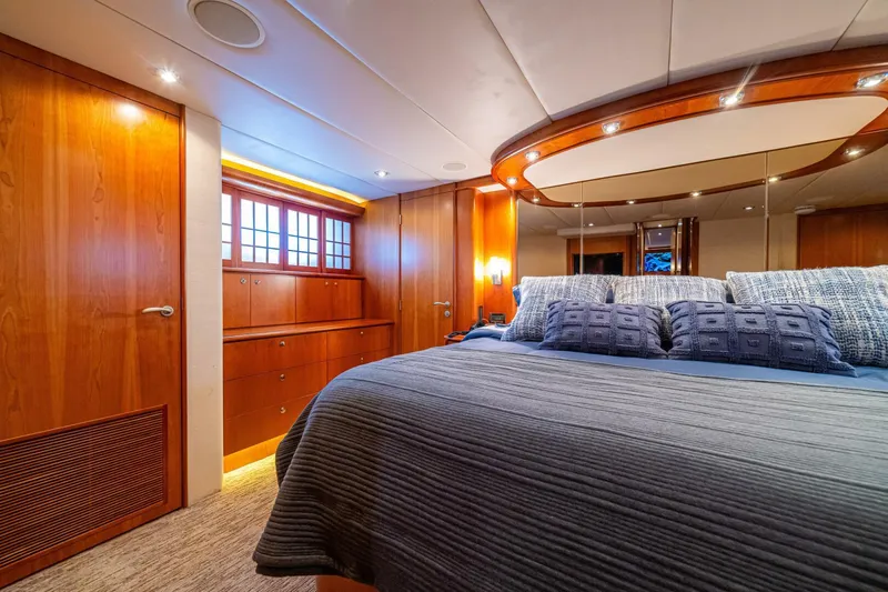 Prime Time Yacht Photos Pics Luxurious bedroom interior of 2002 Queenship 98 Yachtfish with elegant wood finishes.
