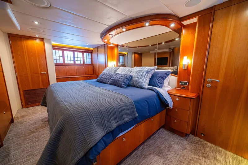 Prime Time Yacht Photos Pics Luxurious bedroom interior on 2002 Queenship 98 Yachtfish, featuring elegant wood finishes and plush bedding.