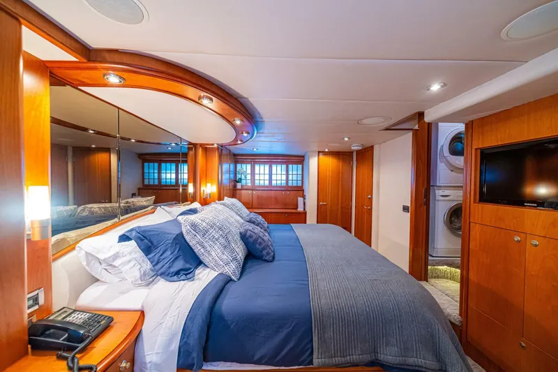 Prime Time Yacht Photos Pics Luxurious bedroom interior of 2002 Queenship 98 Yachtfish, featuring elegant wood finishes and modern amenities.