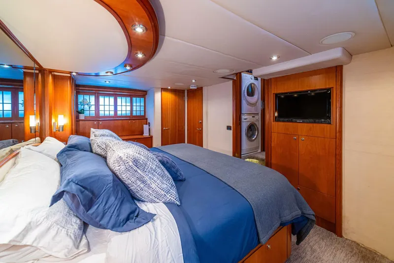 Prime Time Yacht Photos Pics Luxurious bedroom in 2002 Queenship 98 Yachtfish with elegant wood finishes and modern amenities.