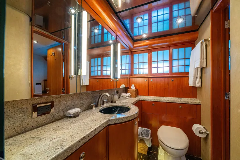 Prime Time Yacht Photos Pics Luxurious bathroom on 2002 Queenship 98 Yachtfish, featuring elegant wood cabinetry and modern fixtures.