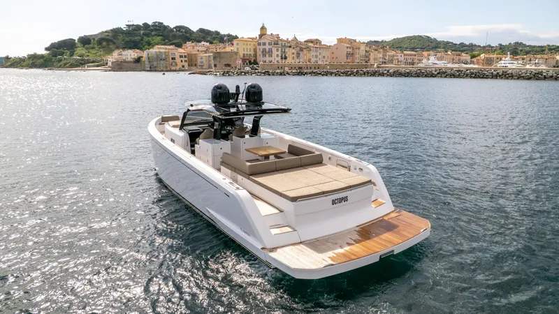  Yacht Photos Pics 2024 Pardo Yachts 50 cruising near a coastal town, showcasing sleek design and powerful engines.