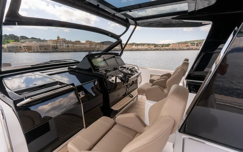  Yacht Photos Pics 2024 Pardo Yachts 50 cockpit with luxurious seating and modern controls, overlooking scenic waterfront.