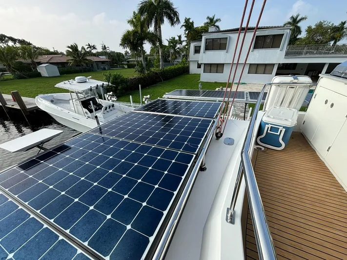  Yacht Photos Pics 2019 Leopard 58 yacht with solar panels, docked near a house.