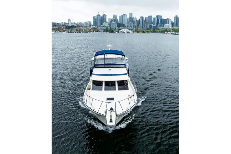 Blue Fish Yacht Photos Pics 1988 Tollycraft 44CPMY yacht cruising with city skyline in the background.