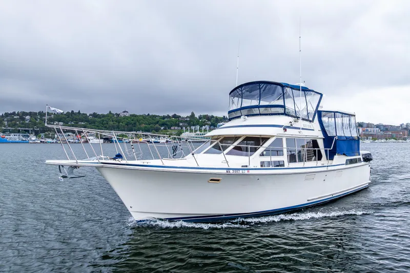 Blue Fish Yacht Photos Pics 1988 Tollycraft 44CPMY yacht cruising on a scenic waterway under cloudy skies.