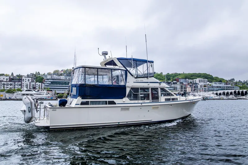 Blue Fish Yacht Photos Pics 1988 Tollycraft 44CPMY yacht cruising on a scenic waterfront.