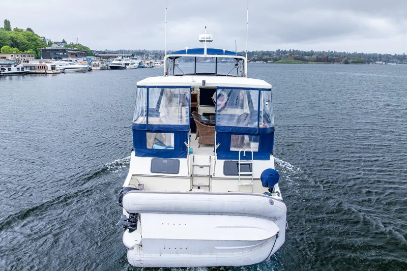Blue Fish Yacht Photos Pics 1988 Tollycraft 44CPMY yacht cruising on a calm lake with scenic shoreline.