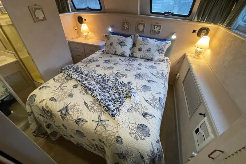 Blue Fish Yacht Photos Pics Cozy bedroom in 1988 Tollycraft 44CPMY yacht with nautical-themed bedding.