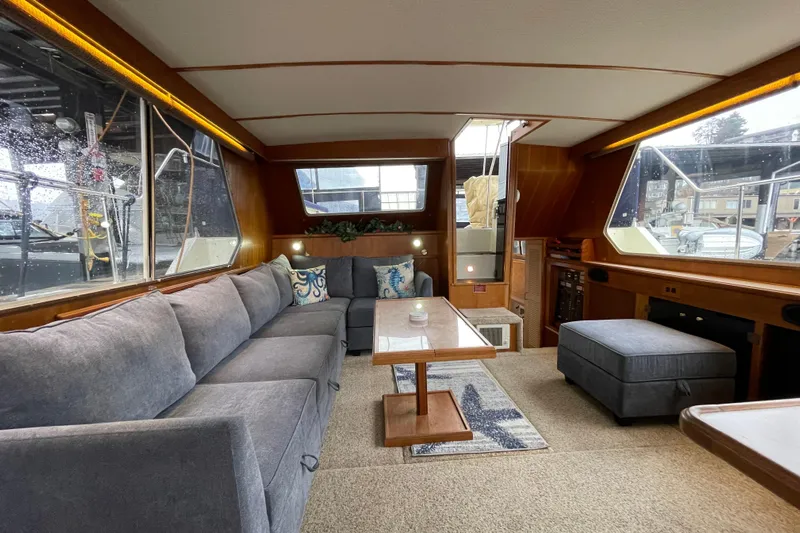 Blue Fish Yacht Photos Pics 1988 Tollycraft 44CPMY yacht interior with cozy seating, wooden accents, and large windows.