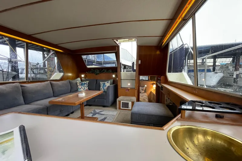 Blue Fish Yacht Photos Pics 1988 Tollycraft 44CPMY yacht interior with cozy seating, wooden accents, and large windows.