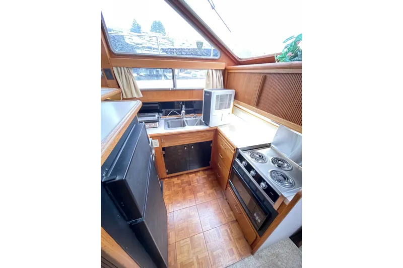 Blue Fish Yacht Photos Pics 1988 Tollycraft 44CPMY yacht kitchen with stove, sink, and refrigerator.