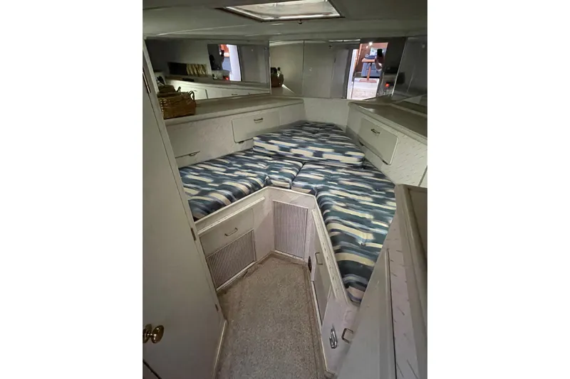 Blue Fish Yacht Photos Pics 1988 Tollycraft 44CPMY cabin interior with striped bedding and storage cabinets.