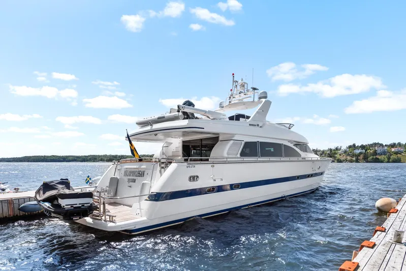  Yacht Photos Pics Luxury yacht Horizon Elegance 80, 2000 model, docked by a scenic waterfront.