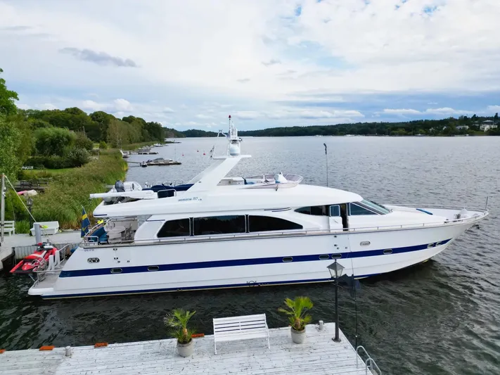  Yacht Photos Pics Luxury yacht Horizon Elegance 80, 2000 model, docked by a scenic lakeside.