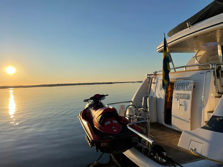  Yacht Photos Pics Luxury yacht Horizon Elegance 80 with jet ski at sunset on calm waters.