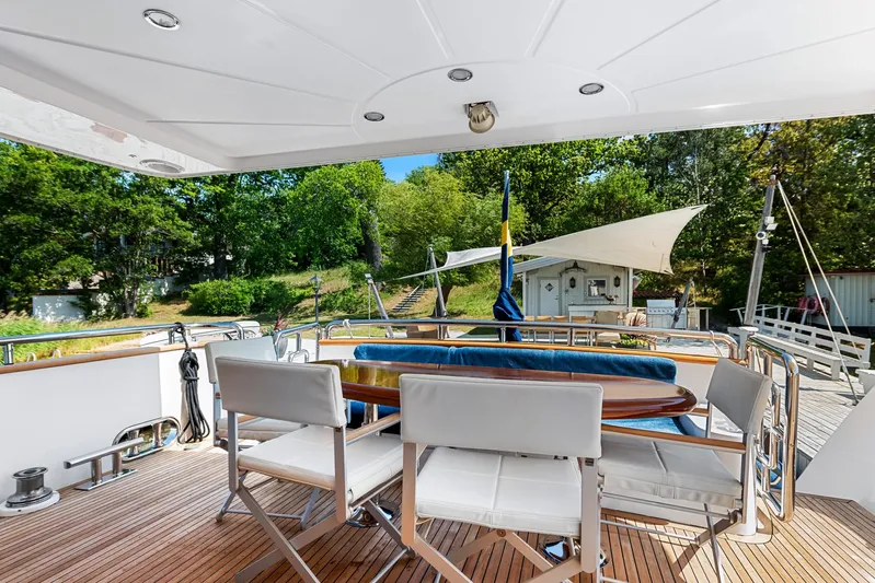  Yacht Photos Pics Luxury yacht deck with seating, Horizon Elegance 80, 2000 model, surrounded by lush greenery.