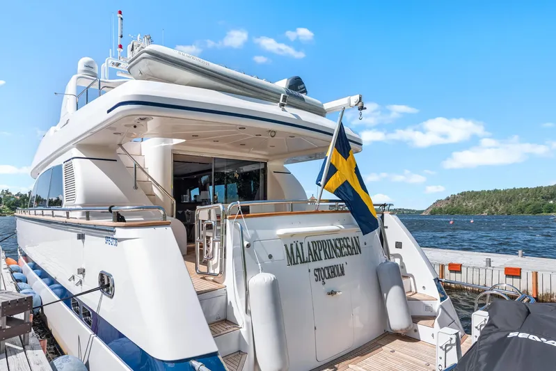  Yacht Photos Pics Luxury yacht Horizon Elegance 80, 2000 model, docked with Swedish flag, scenic waterfront view.