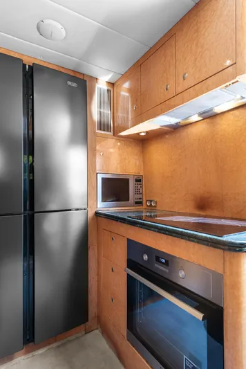  Yacht Photos Pics Modern kitchen in 2000 Horizon Elegance 80 yacht with sleek appliances and wood cabinetry.